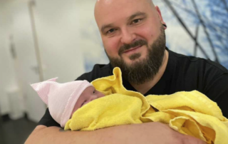 So sieht Glück aus: Unser Mitarbeiter Dennis Burkert hält die neugeborene Tochter Lotta auf dem Arm.