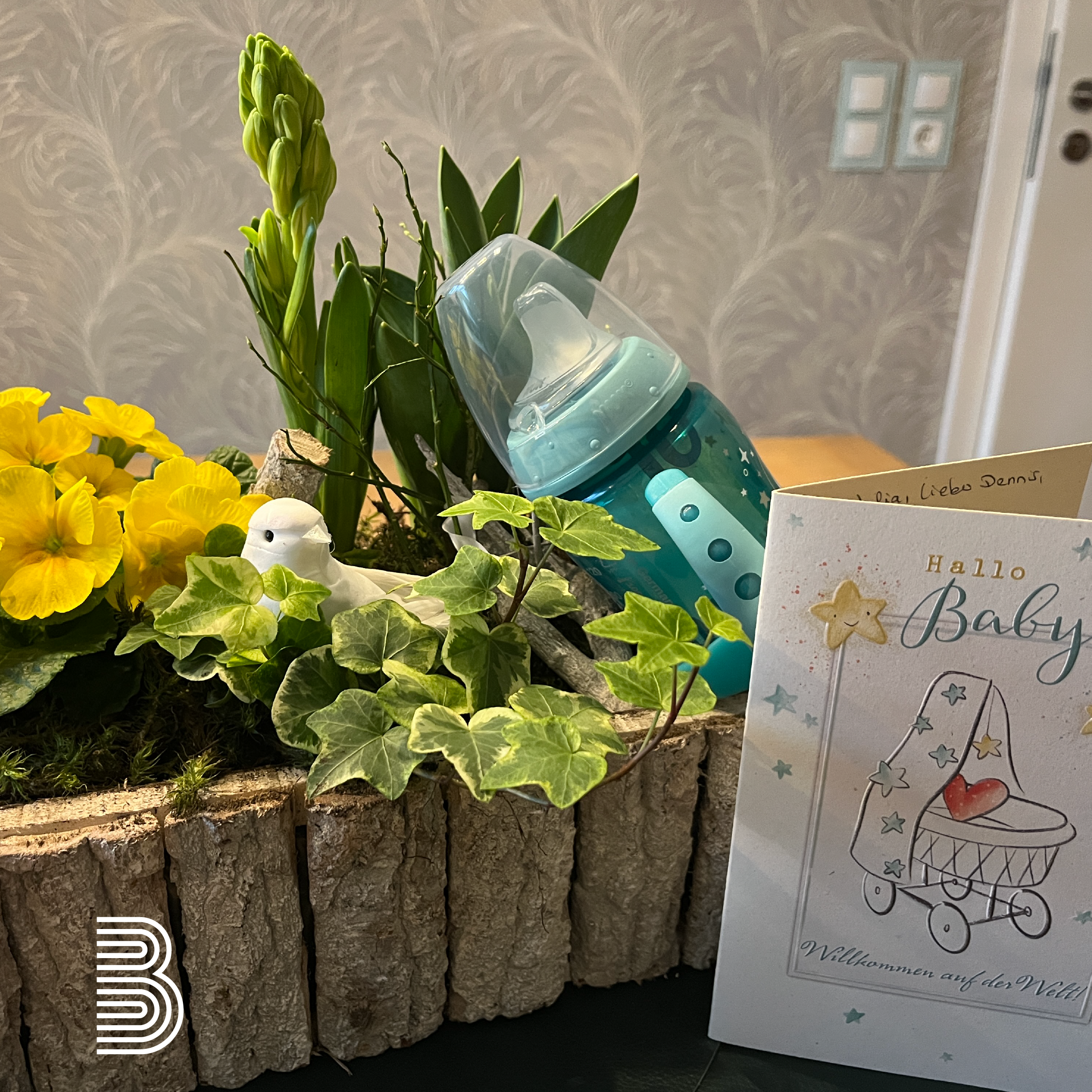 2024_01_baby_kachel Baby-Geschenk mit Flasche und Blumen.