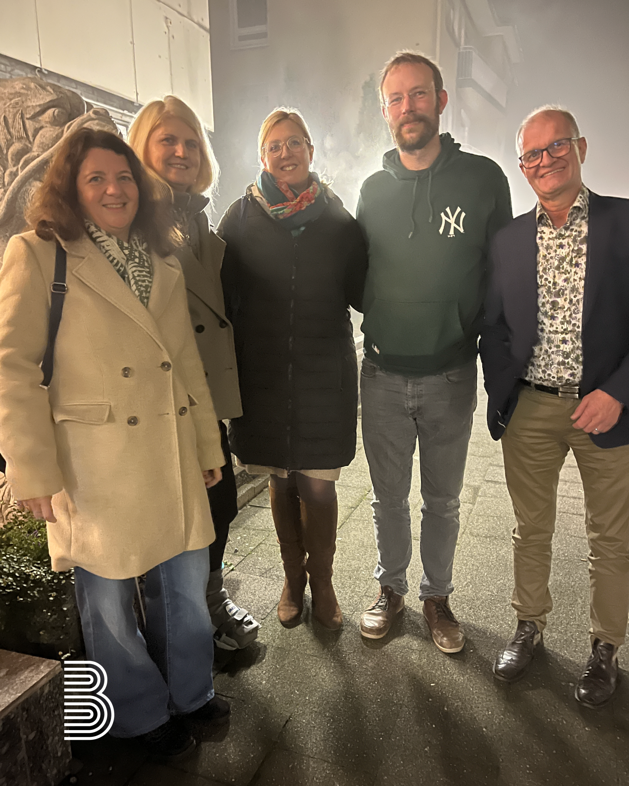 2025_12_japanisch_essen Ein Teil des Teams der Firma Berse steht nebeneinander beim Restaurantbesuch.