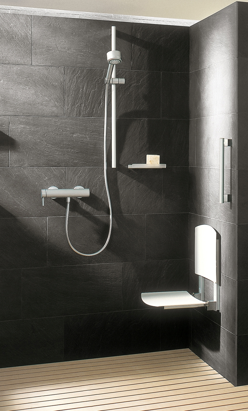 Eine Dusche mit in der Wand montiertem Duschsitz.