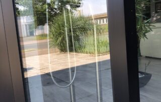 Ein QR-Code klebt an einer gläsernen Eingangstür.