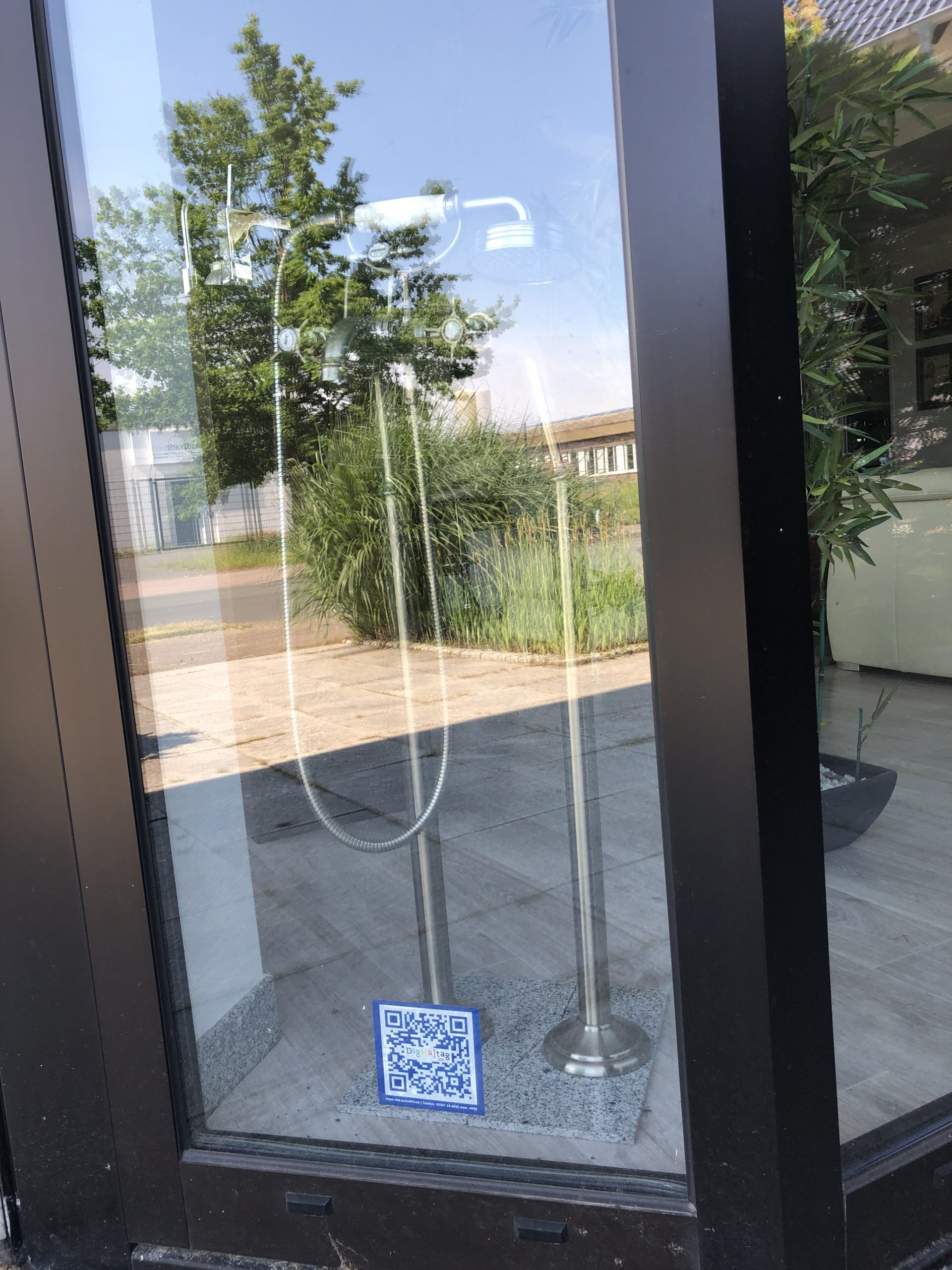 digitaltag_2021_gedreht Ein QR-Code klebt an einer gläsernen Eingangstür.