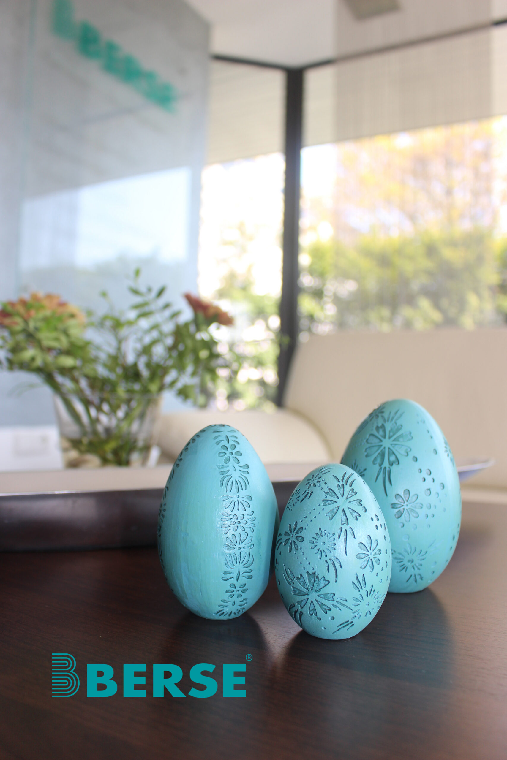 img_5623_mitberse_logo_bearbeitet-1 Drei türkisfarbene Ostereier stehen in der Firma Berse auf der Theke.