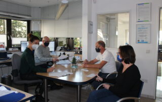 Coaching-Situation in der Firma Berse. Menschen sitzen gemeinsam an einem Tisch.