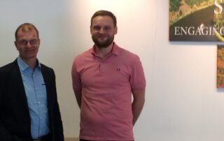 Ulrich Berse mit Daniel Goorkotte (Firma Elting) beim Firmenbesuch von Villeroy & Boch vor einem Logo von Villeroy & Boch.