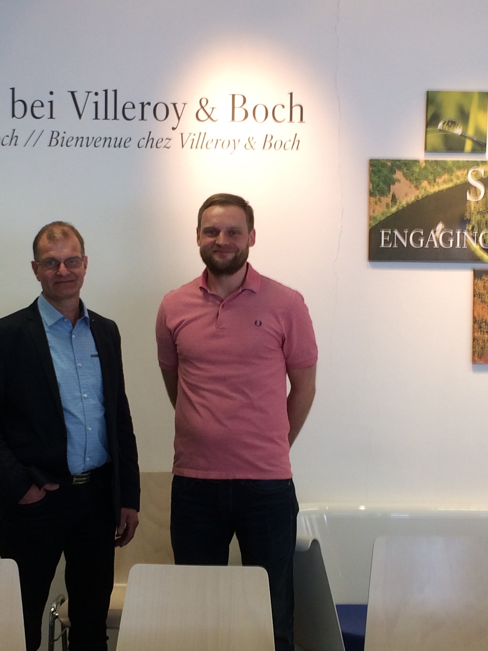 img_9304_klein Ulrich Berse mit Daniel Goorkotte (Firma Elting) beim Firmenbesuch von Villeroy & Boch vor einem Logo von Villeroy & Boch.