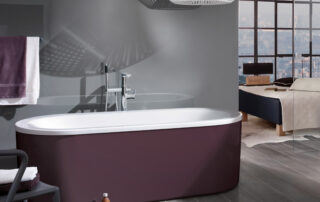 Eine lilafarbene Badewanne im klassichen Stil steht in einem stilvollen Badezimmer-Ambiente.