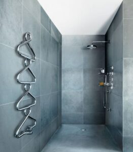 Ein Designer-Heizkörper hängt neben einer Dusche.